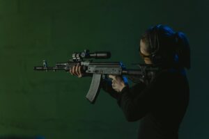 person looking at the target while holding a rifle