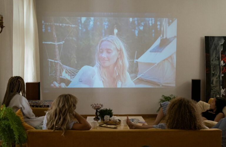 women sitting on the sofa while watching a movie